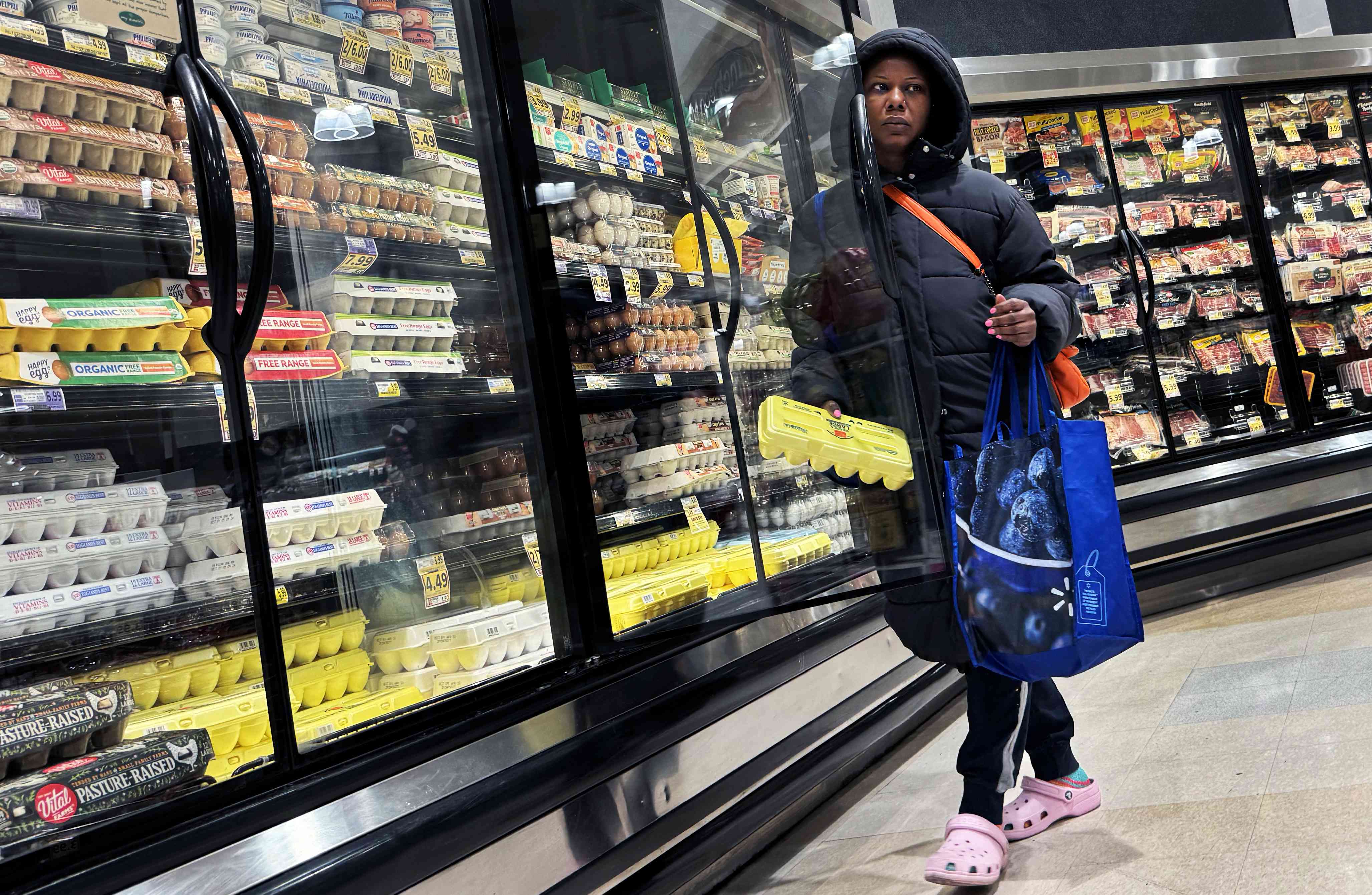 A shopper takes a carton of eggs from the cooler in a grocery store in Washington, D.C., on Saturday, April 6, 2024.